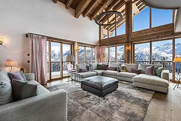 A living room with a large sectional couch and ottoman