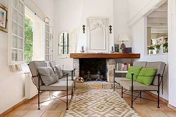 A living room with a fireplace and two chairs