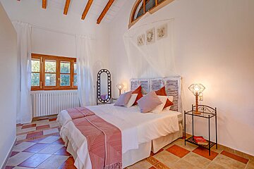 A bedroom with a canopy bed and a mirror
