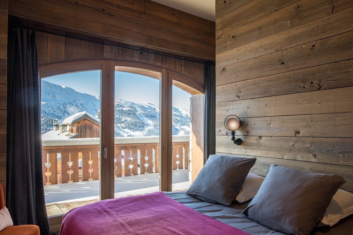 A bedroom with a bed and a view of the mountains