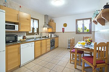 A kitchen with a table and chairs and a microwave