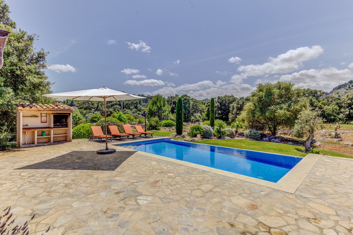A large swimming pool surrounded by chairs and an umbrella