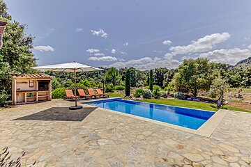A large swimming pool surrounded by chairs and an umbrella