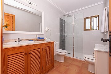 A bathroom with two toilets and a walk in shower