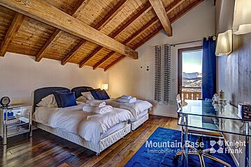 A bedroom with two beds and a desk from mountain base knight frank