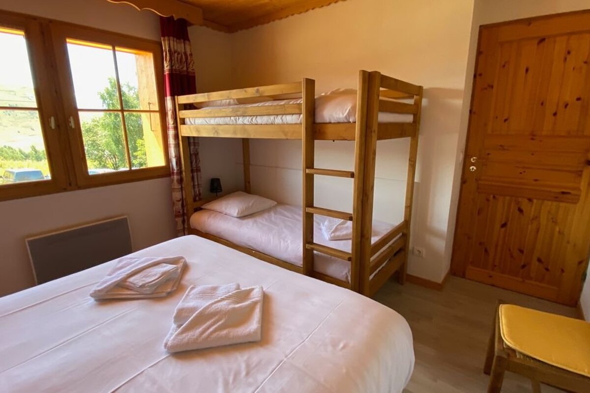 A bedroom with a bunk bed and a chair