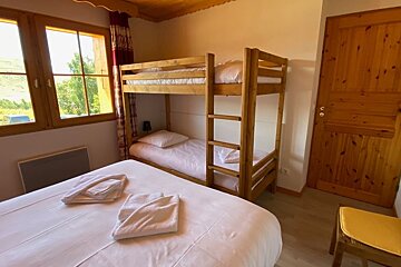 A bedroom with a bunk bed and a chair