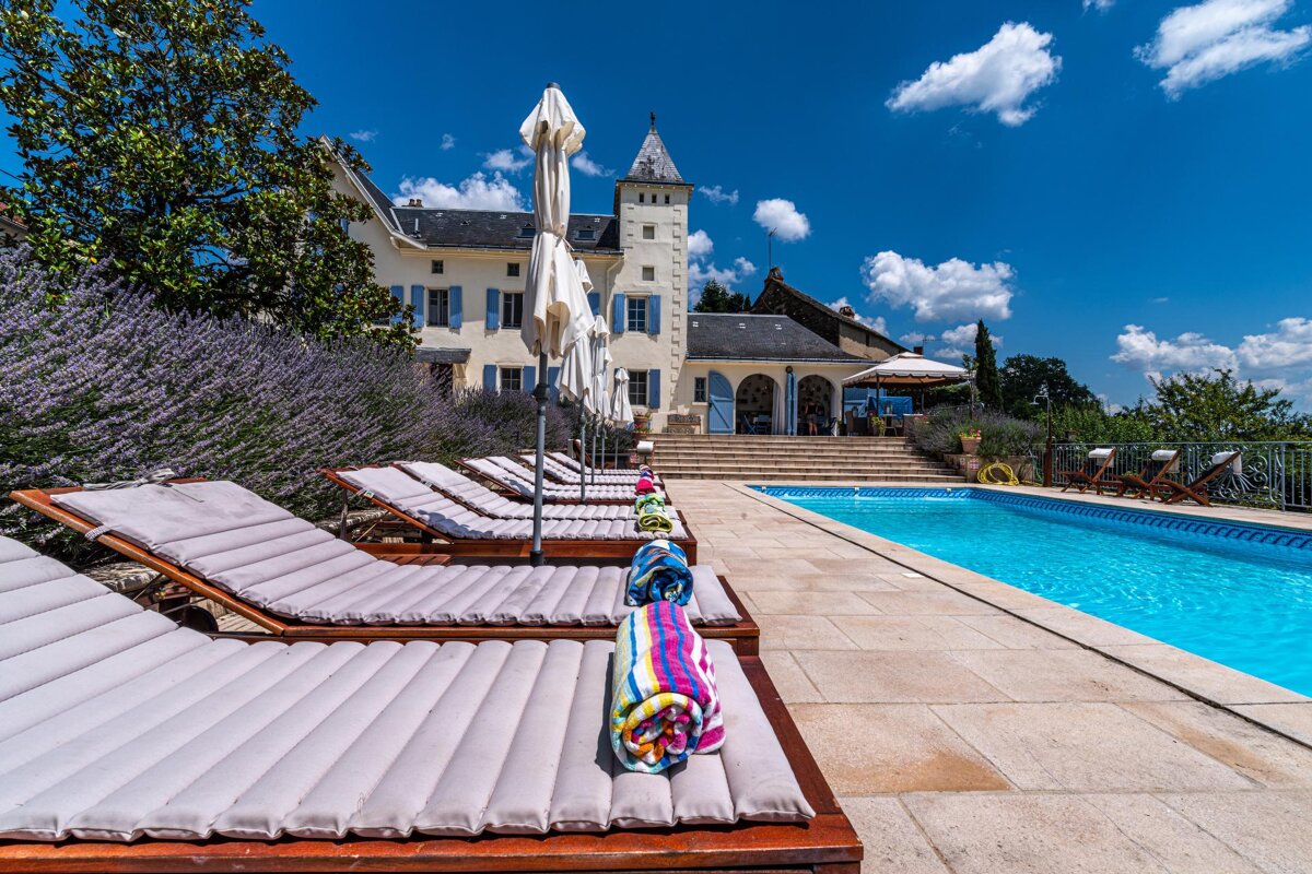 A row of lounge chairs next to a large swimming pool