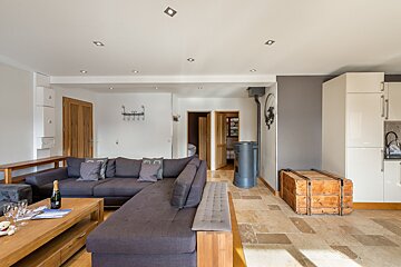 A living room with a large sectional couch and a wooden trunk