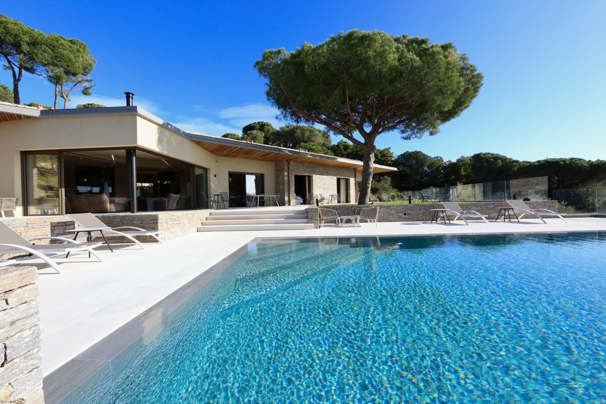 A large swimming pool in front of a house