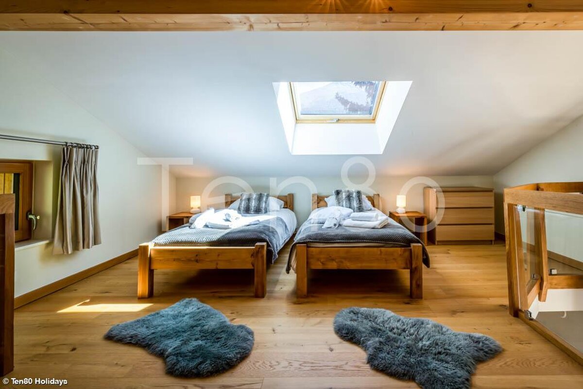 A bedroom with two beds and a skylight taken by tango holidays
