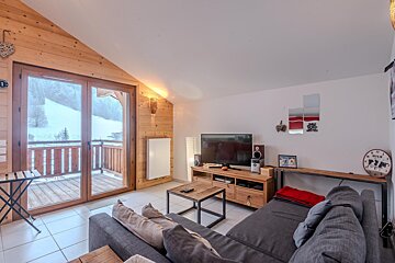 A living room with a couch and a clock that has the number 12 on it