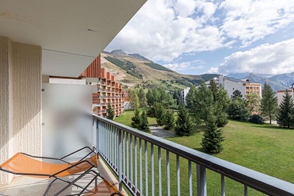 A balcony with a view of mountains and trees