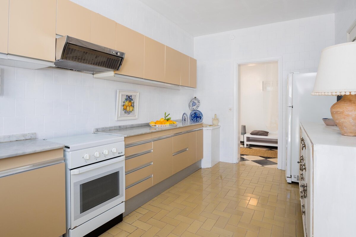 A kitchen with tan cabinets and a white stove