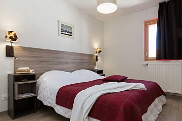 A bedroom with a bed and a picture on the wall