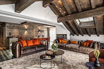 A living room with a brown couch and orange pillows