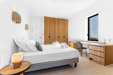 A bedroom with a bed and a desk with the number 100 on the wall