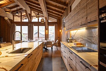 A kitchen with wooden cabinets and marble counter tops