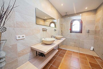 A bathroom with two sinks and a walk in shower