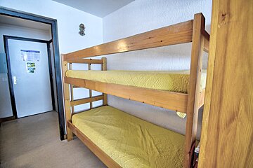 A bunk bed with a yellow blanket in a room