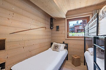 Three bunk beds in a room with a rug on the floor