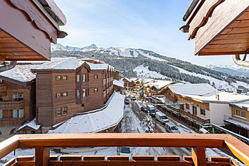 A view of a snowy mountain town from a balcony