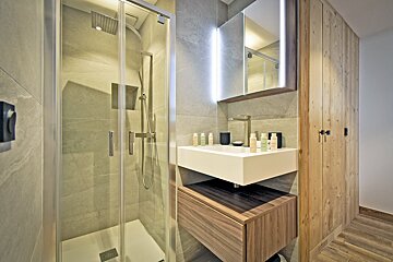 A bathroom with a sink and a shower stall