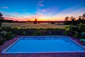 A large swimming pool with a sunset in the background