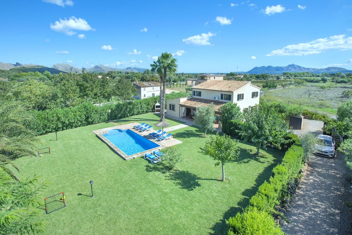 An aerial view of a house with a large swimming pool