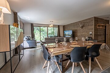 A dining table and chairs in a living room