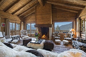 A living room with a fireplace and a view of the mountains
