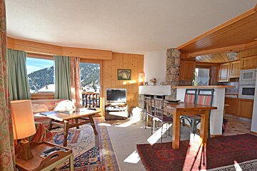 A living room with a table and chairs and a television