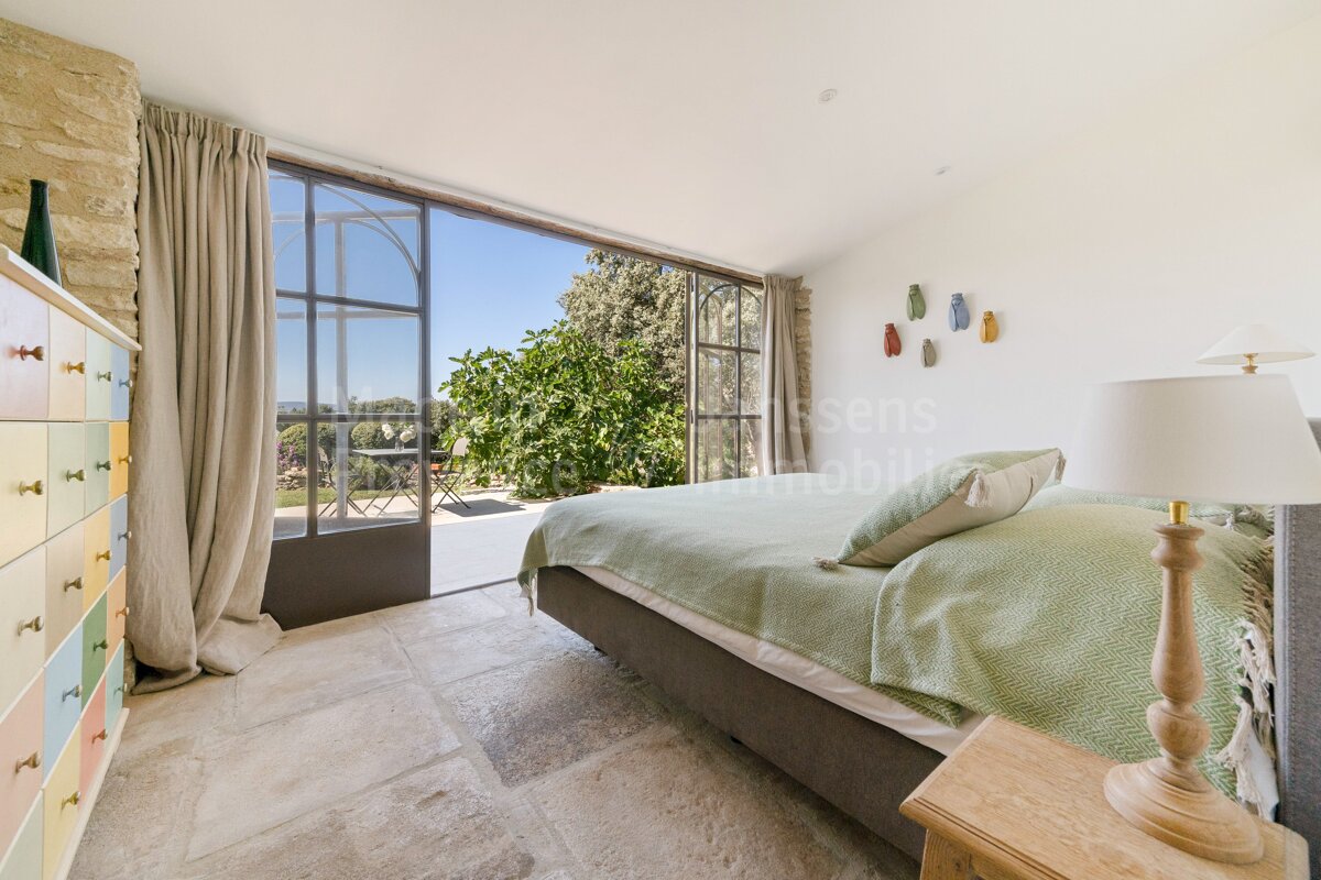 A bedroom with a bed and a lamp and a sign that says sens immobilier