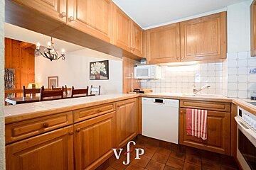 A kitchen with wooden cabinets and a white dishwasher