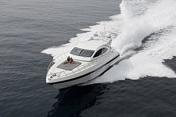 A man sits on the deck of a boat in the ocean