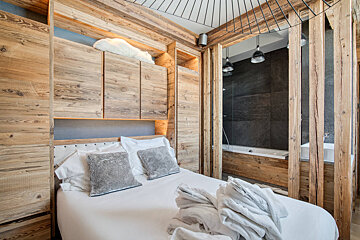 A wooden bench with pillows and a mirror in a hallway