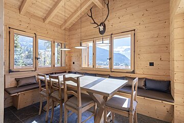 A wooden dining room with a table and chairs
