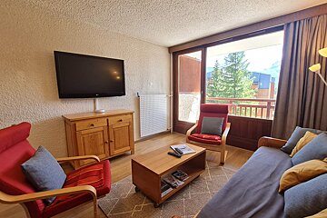 A living room with a couch a chair and a flat screen tv