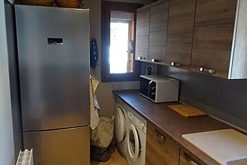 A kitchen with a stainless steel refrigerator and a microwave