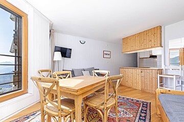 A living room with a wooden table and chairs