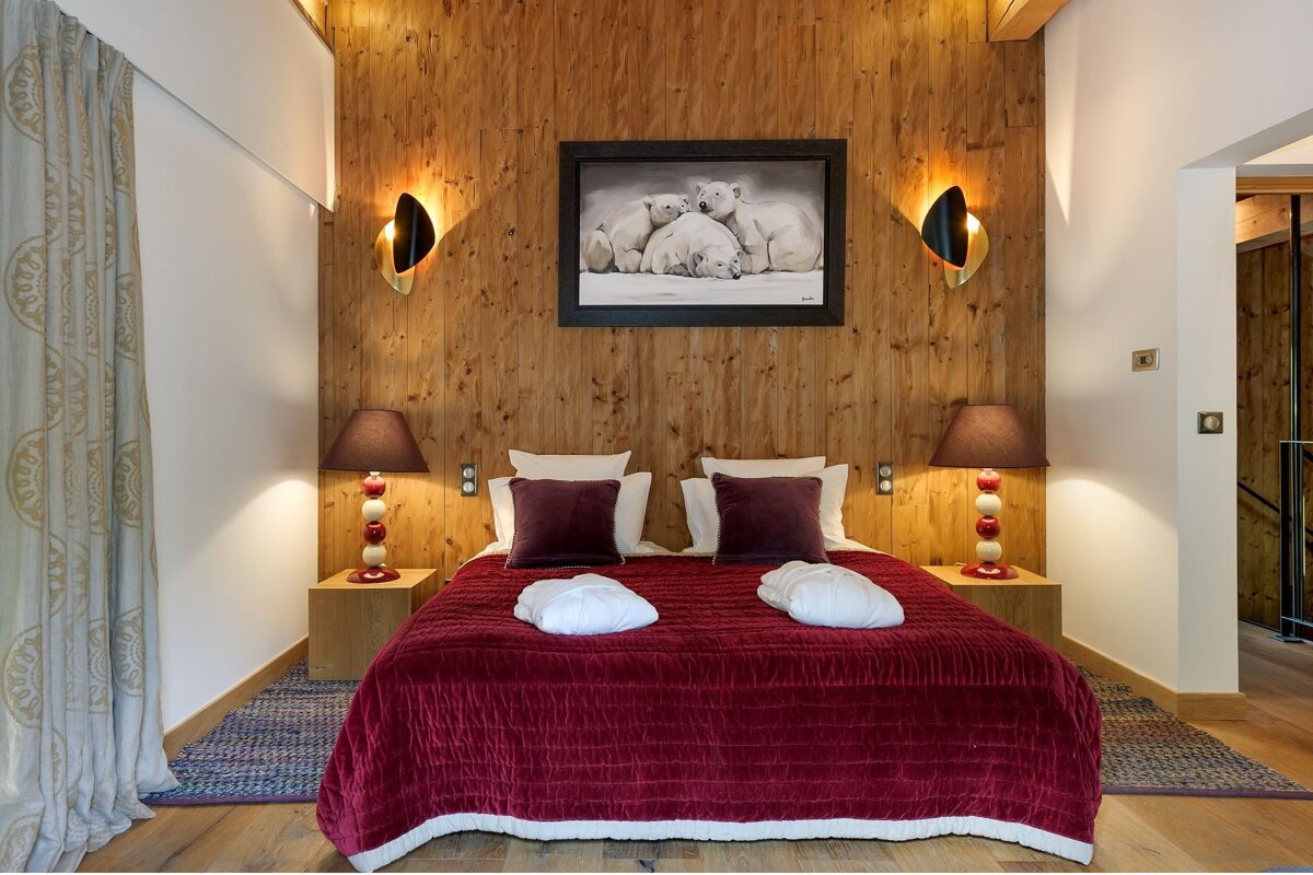 A bedroom with a picture of polar bears on the wall above the bed