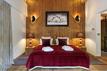 A bedroom with a picture of polar bears on the wall above the bed