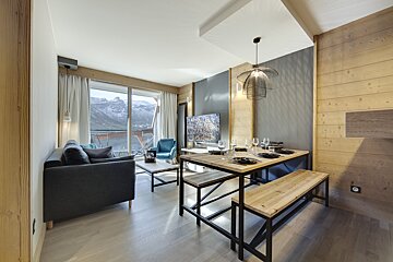 A living room with a black couch and a wooden table