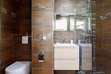 A bathroom with brown tiles and a sign that says home studio