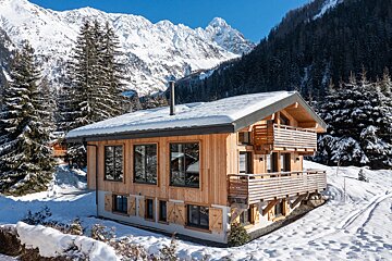 A house in the snow with a mountain in the background