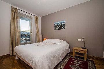 A bedroom with a painting on the wall above the bed