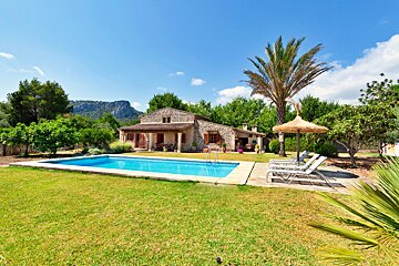 A house with a large swimming pool in front of it
