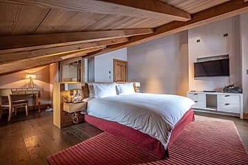 A bedroom with a large bed and a flat screen tv