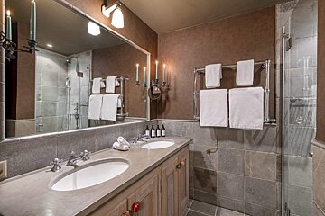 A bathroom with two sinks and candles on the wall