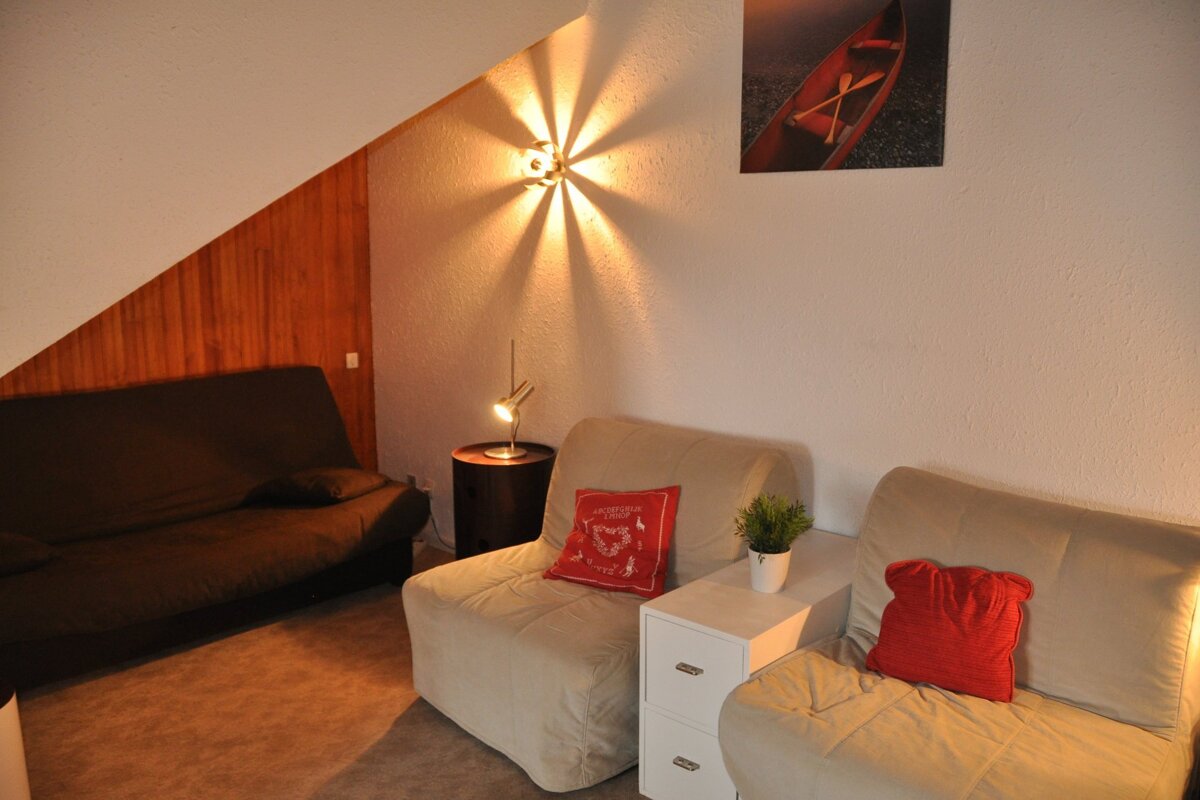 A living room with two chairs and a couch and a picture of a canoe on the wall